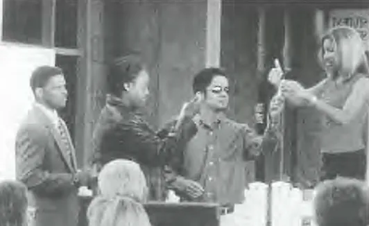 A group of people stand for a presentation in front of a building, black and white photo