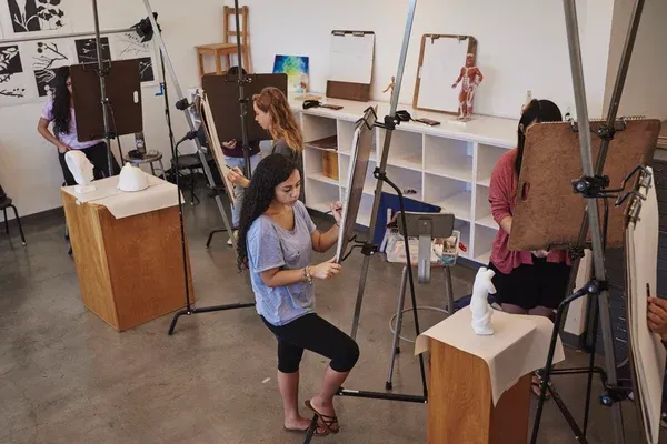 Students work on easels in an art studio